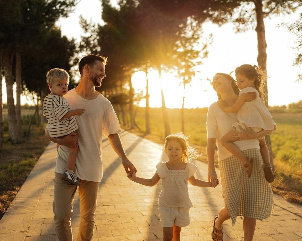 Família caminhando de mãos dadas ao pôr do sol